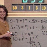 A presenter beside a numbers puzzle and handwritten calculations