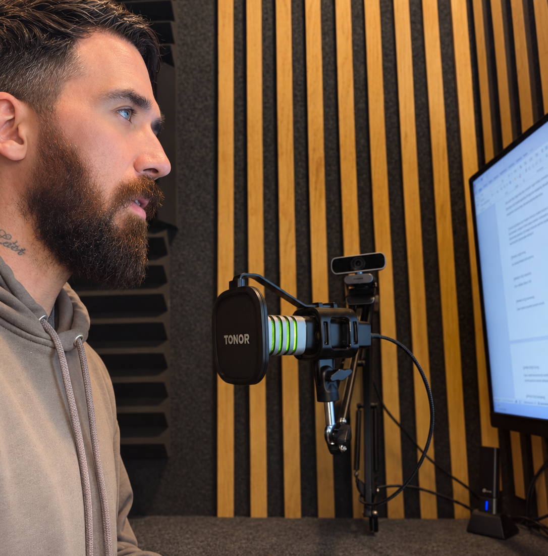 Side-profile portrait at a green-lit microphone in a recording studio.